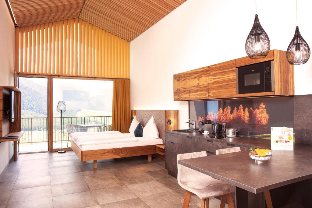 Pokój z kuchnią z łóżkiem i stołem w obiekcie Panorama Lodges Plagött w mieście San Valentino alla Muta