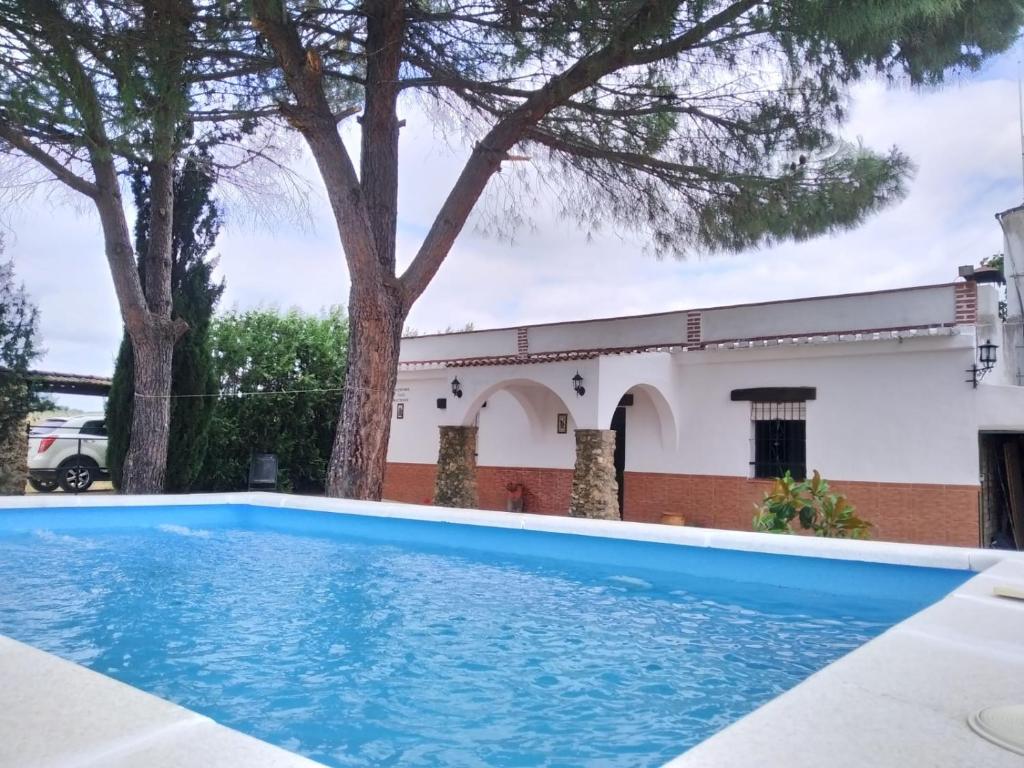 a blue swimming pool in front of a building at Casa Rural San Antonio in La Puebla de los Infantes