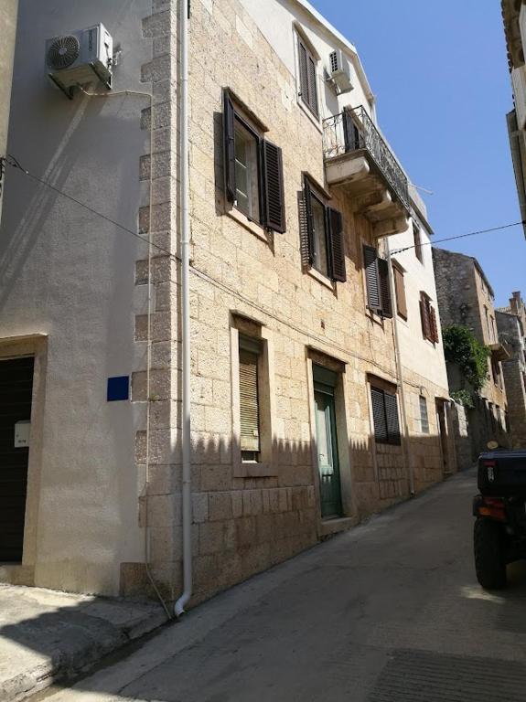 a building with a balcony on the side of a street at Apartman Dina in Komiža