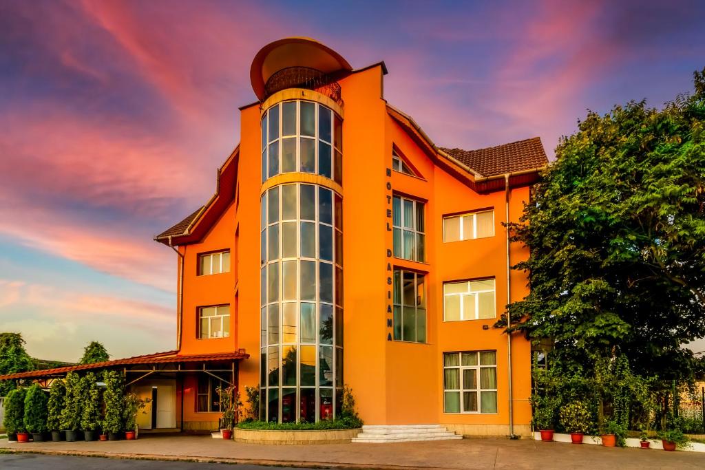 un bâtiment orange avec une grande fenêtre dans l'établissement Motel Dasiana, à Târgu Jiu