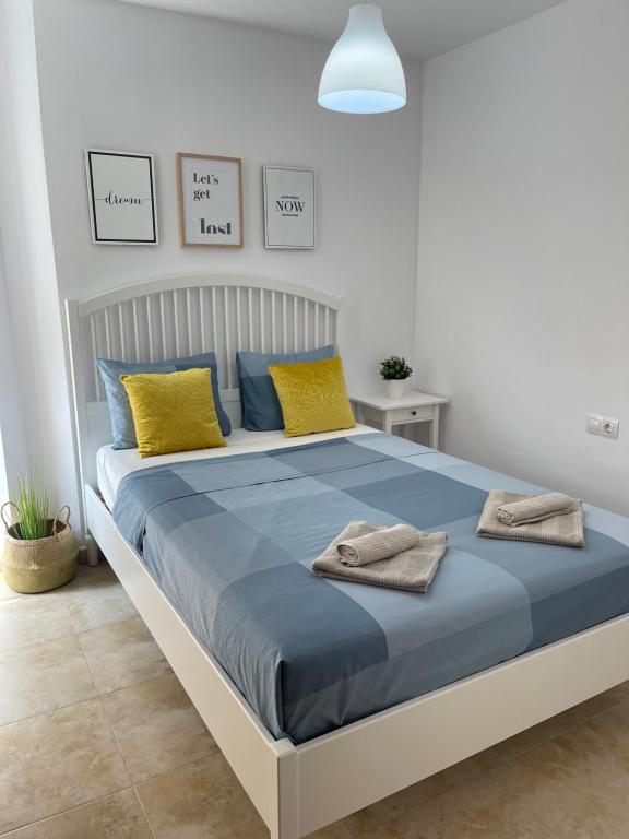 a bedroom with a large bed with yellow and blue pillows at UIM Mediterraneo PB Felipe 1 Wifi in Puerto de Sagunto