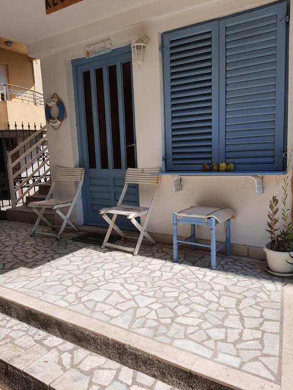 two chairs and a table on the porch of a house at Vojinovic Apartments in Budva