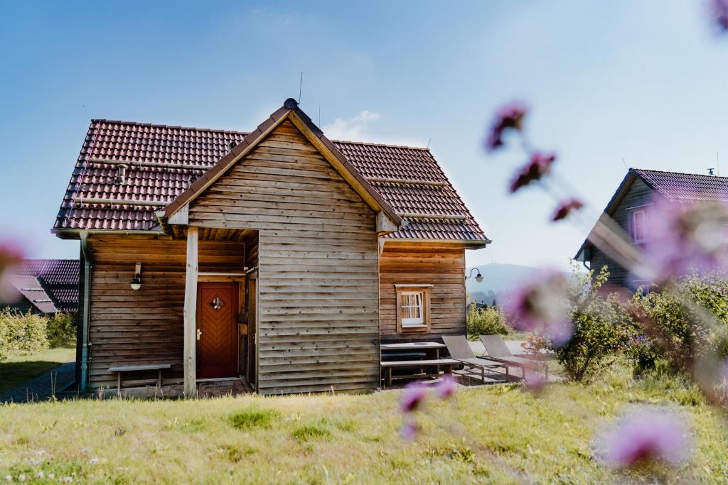 a small wooden house with a door in a field at Torfhaus Harzresort in Torfhaus