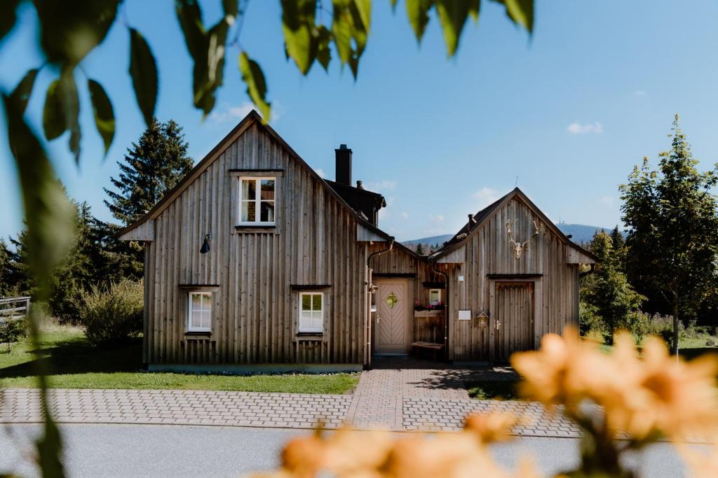 uma grande casa de madeira com garagem em Torfhaus Harzresort em Torfhaus