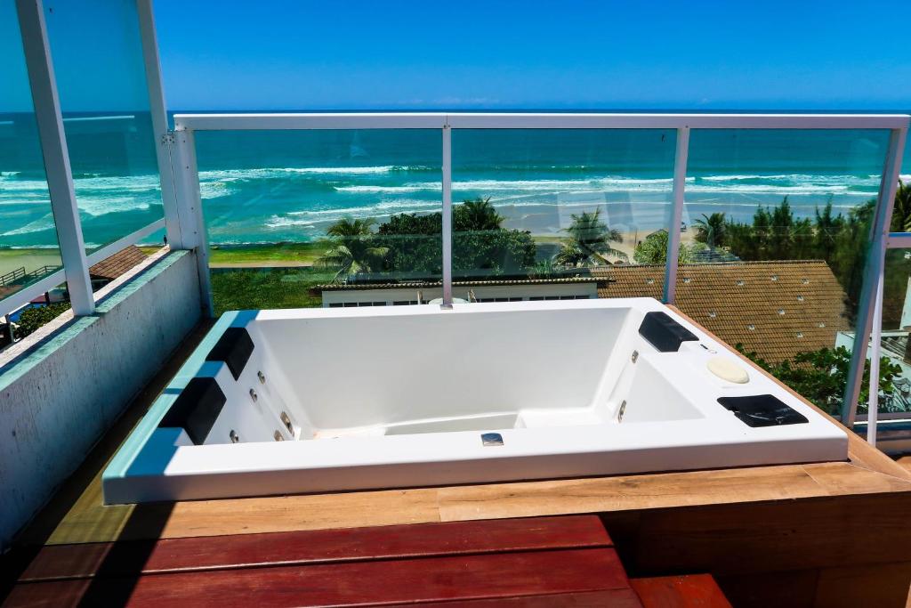 a bath tub on a balcony with a view of the ocean at Terra Nostra Residence in Porto De Galinhas