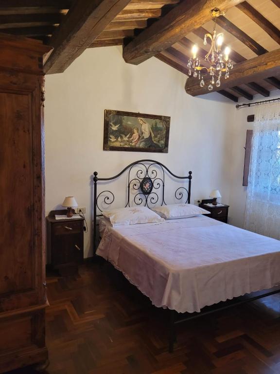 sypialnia z łóżkiem i żyrandolem w obiekcie Agriturismo "Apparitoio" w mieście Montelaterone