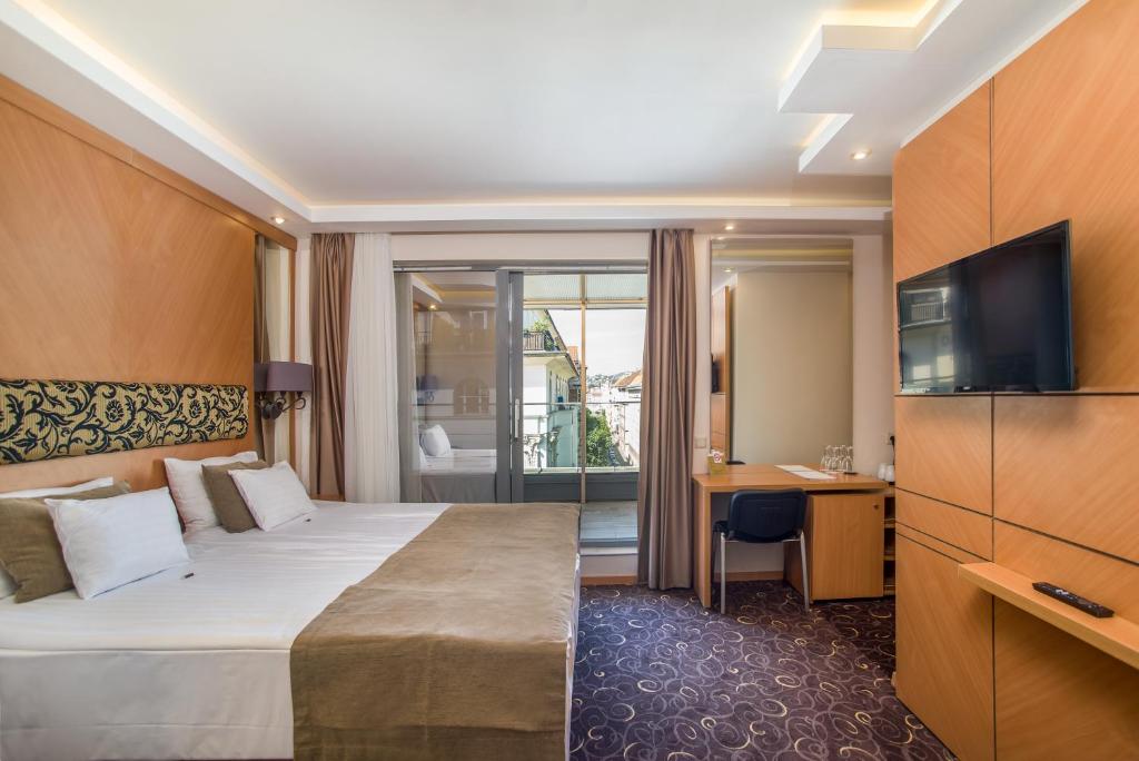 um quarto de hotel com uma cama e uma televisão em Marmara Hotel Budapest em Budapeste