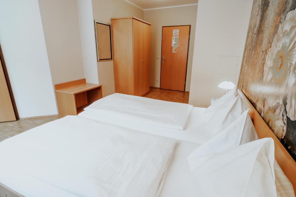 Postel nebo postele na pokoji v ubytování Hotel am Kapuzinerplatz