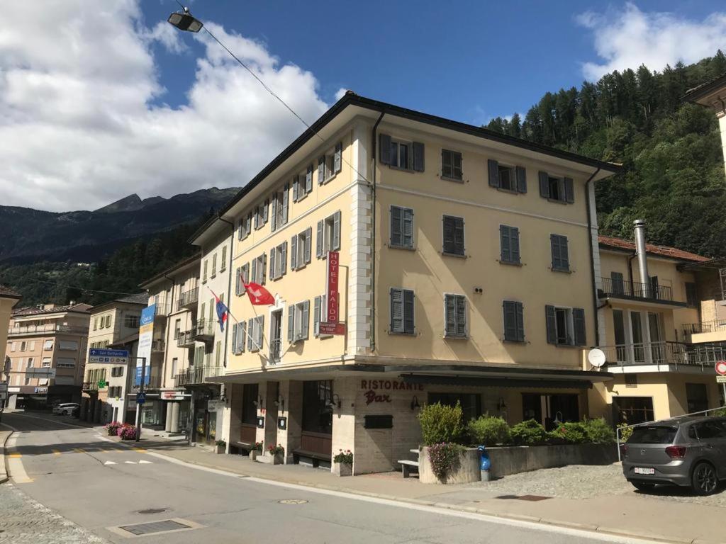 un grand bâtiment sur le côté d'une rue dans l'établissement Albergo Faido, à Faido