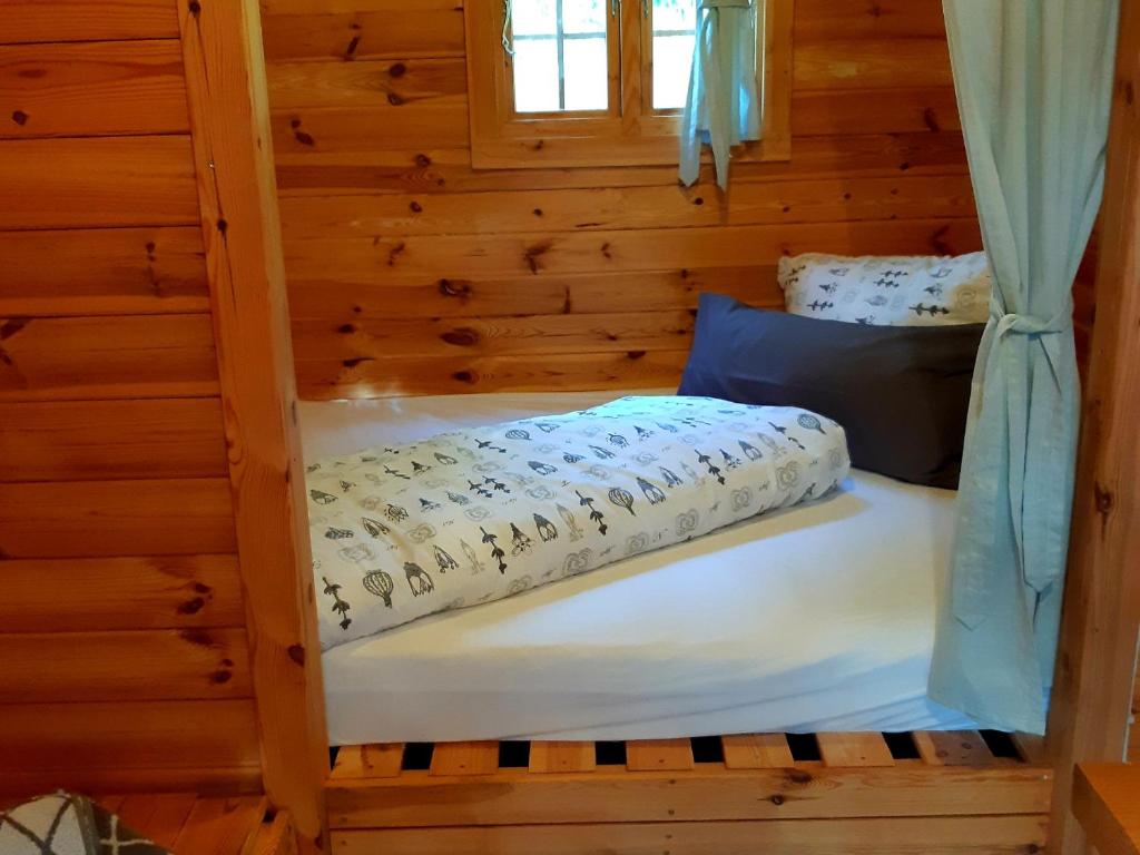 a bunk bed in a log cabin with a window at PODs Alte Schule in Elchweiler