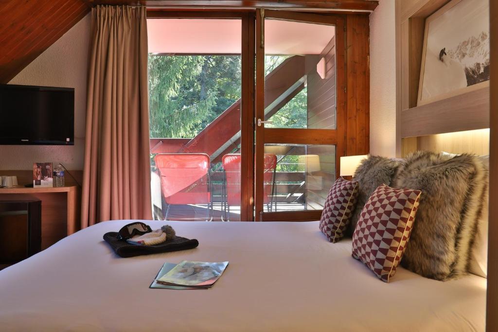 Postel nebo postele na pokoji v ubytování SOWELL HOTELS Mont Blanc et SPA