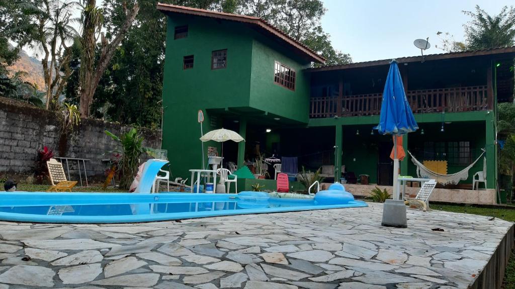 a house with a swimming pool in front of a house at Chalé Vagalume Boiçucanga in Boicucanga