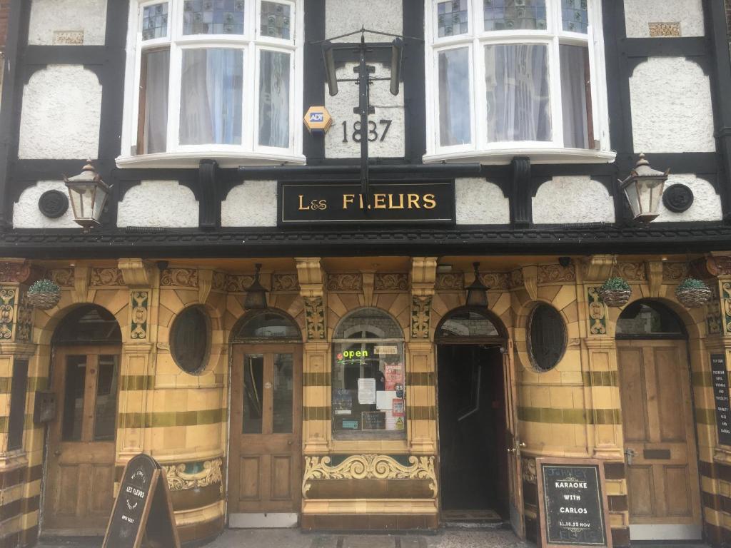 un edificio con una señal que nos lee flirteos en Les Fleurs Accommodation, en Dover