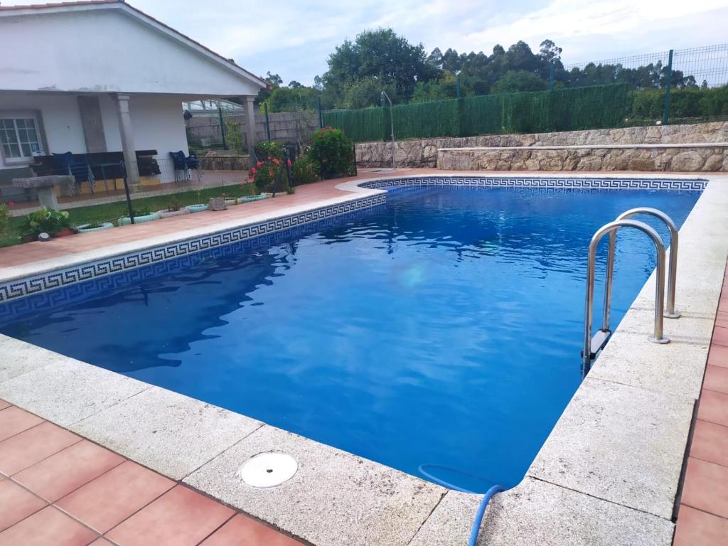 - une piscine d'eau bleue dans la cour dans l'établissement El remanso de José, à A Xesteira