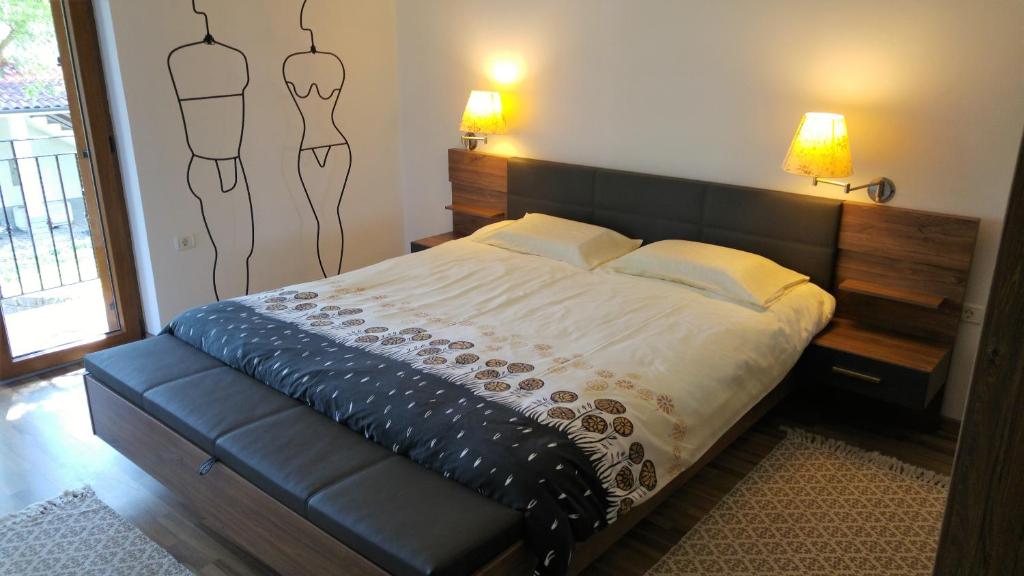 a bedroom with a bed with a black leather headboard at Kmetija Jogan, Wines & Apartments in Pobegi