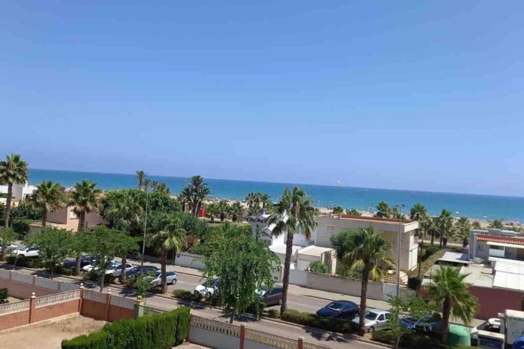 a view of a parking lot with palm trees and the ocean at Appartement "Los Pinos" vue sur mer imprenable in Grao de Castellón