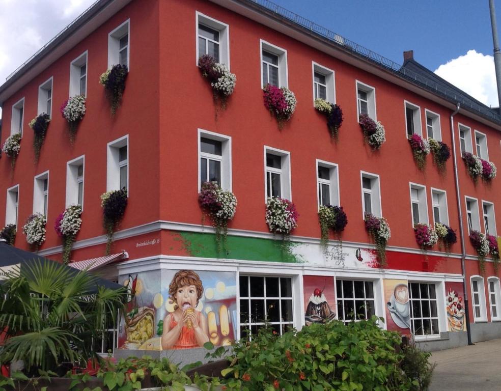 a red building with flowers on the windows at Apartment Enno in Auerbach