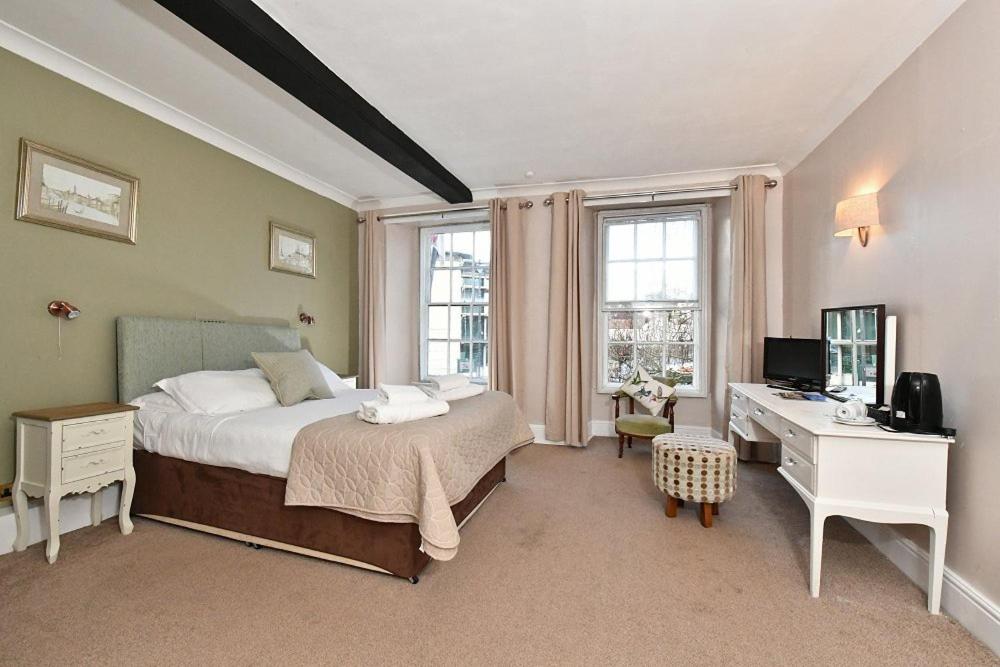 a bedroom with a bed and a desk with a computer at Lansdowne Strand in Calne