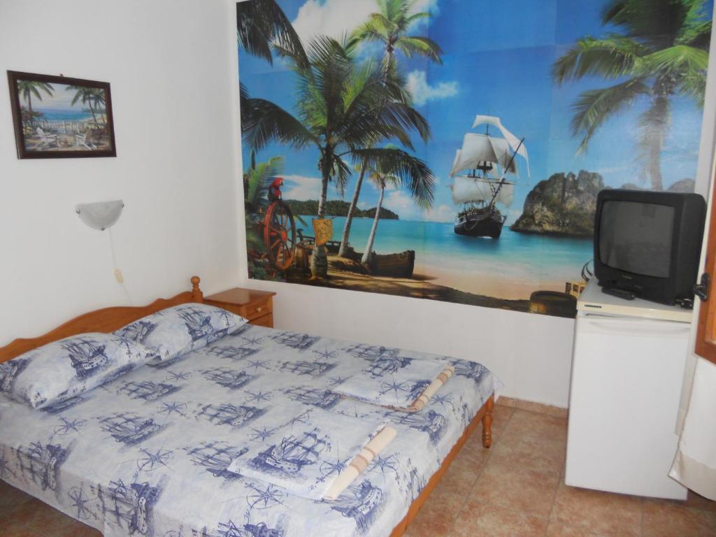 a bedroom with a bed and a tv and a painting at "Aхтополис" - подсигурено безплатно паркиране in Ahtopol