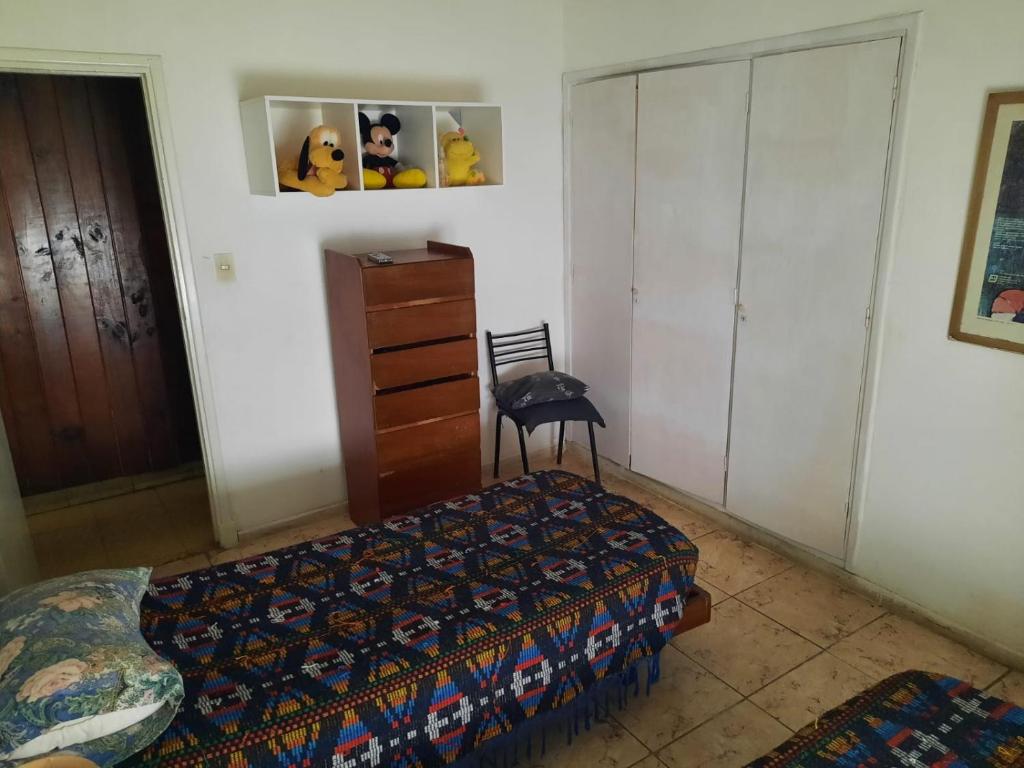 1 dormitorio con 1 cama, vestidor y silla en Habitacion solo un huesped masculino hasta 25 años en casa de familia playa terminal centro wifi aire en Mar del Plata