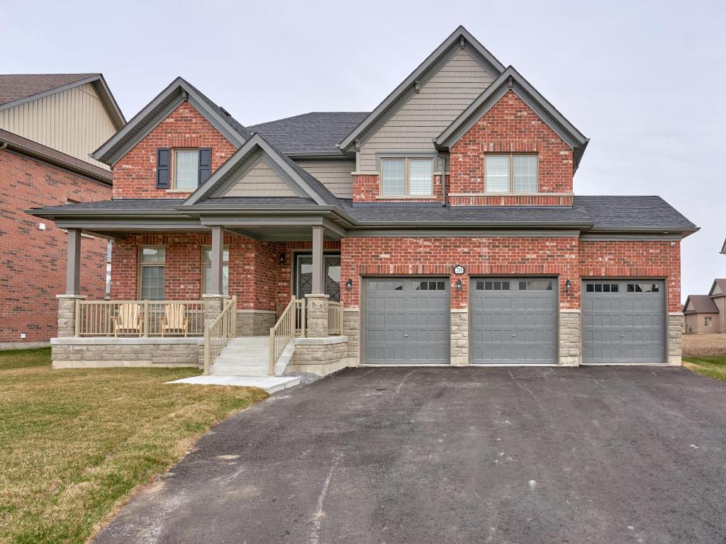 une maison en briques avec deux portes de garage dans une allée. dans l'établissement Entire house for your getaway!, à Carrying Place