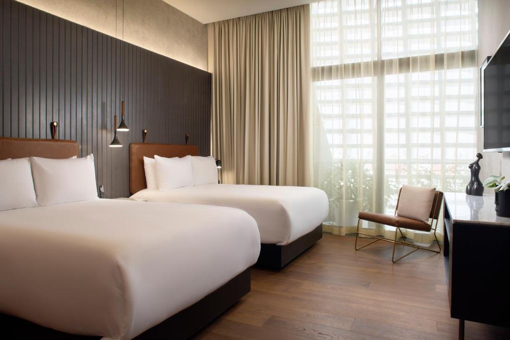 a hotel room with two beds and a chair at Xoma - Luxury Plus by Viadora in Mexico City