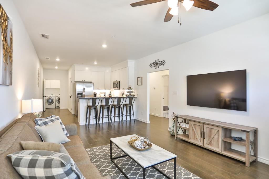 un soggiorno con divano e TV a schermo piatto di Hill Country Haven a Modern Rustic - 2 Bedroom 2 Bathroom Townhouse off Main Street a Fredericksburg