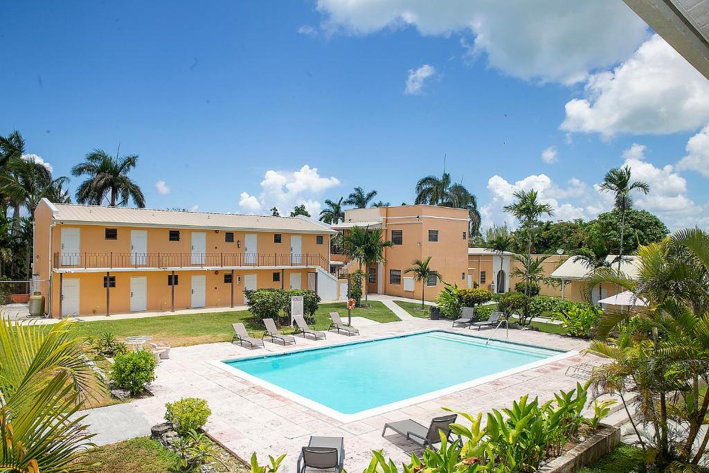 einen Pool mit Stühlen und ein Gebäude in der Unterkunft Orange Hill Beach Inn in Nassau