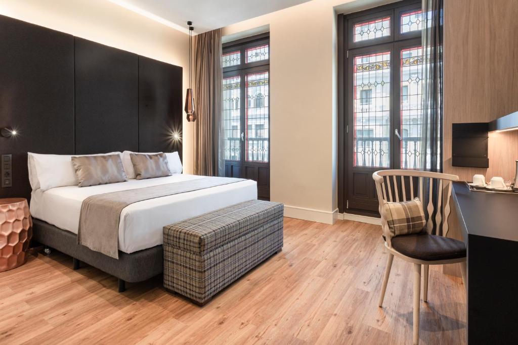 a bedroom with a bed and a desk with a chair at Catalonia Gran Vía Madrid in Madrid
