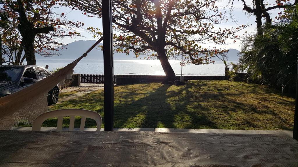 eine Hängematte im Hof mit Blick auf das Wasser in der Unterkunft Casa praia fortaleza pé na areia in Ubatuba