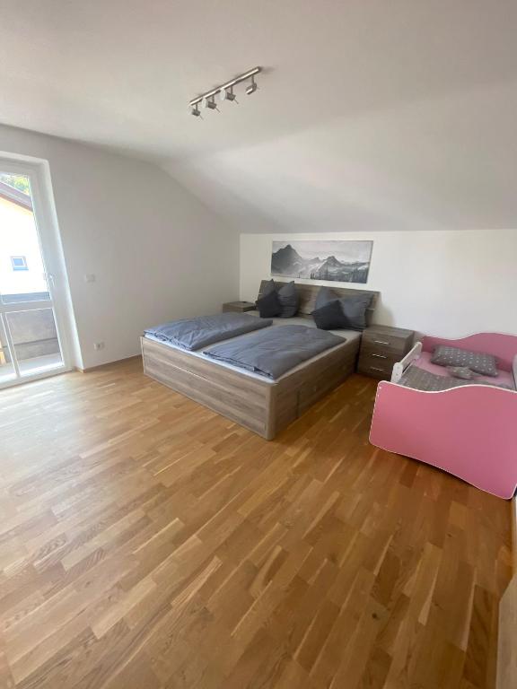 sypialnia z łóżkiem i drewnianą podłogą w obiekcie Ferienhaus Esila w mieście Fieberbrunn