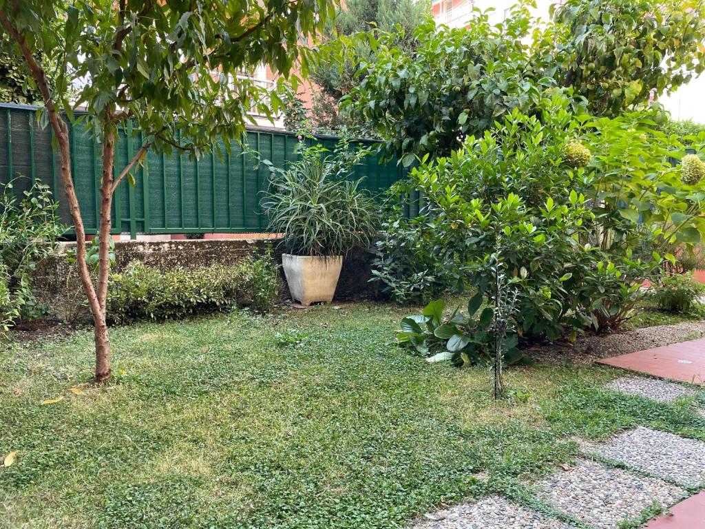 a garden with two trees and a green fence at Il giardino dei limoni in Chiavari