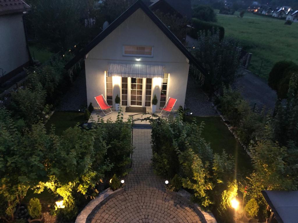 - une vue sur une maison blanche avec 2 chaises rouges dans l'établissement Domek w Pieninach Apartament Pałacowy Liliana, à Krościenko nad Dunajcem