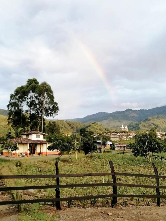 a fence in a field with a house in the background at Finca Hostal Ágora in Jardin
