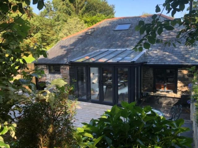 una casa con una gran terraza frente a ella en Riverside Retreat en Totnes