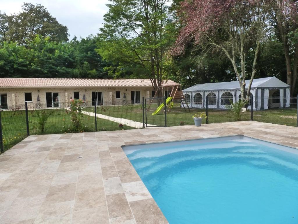 a swimming pool in front of a house at Gîtes les Bernes in Saint-Pardon-de-Conques