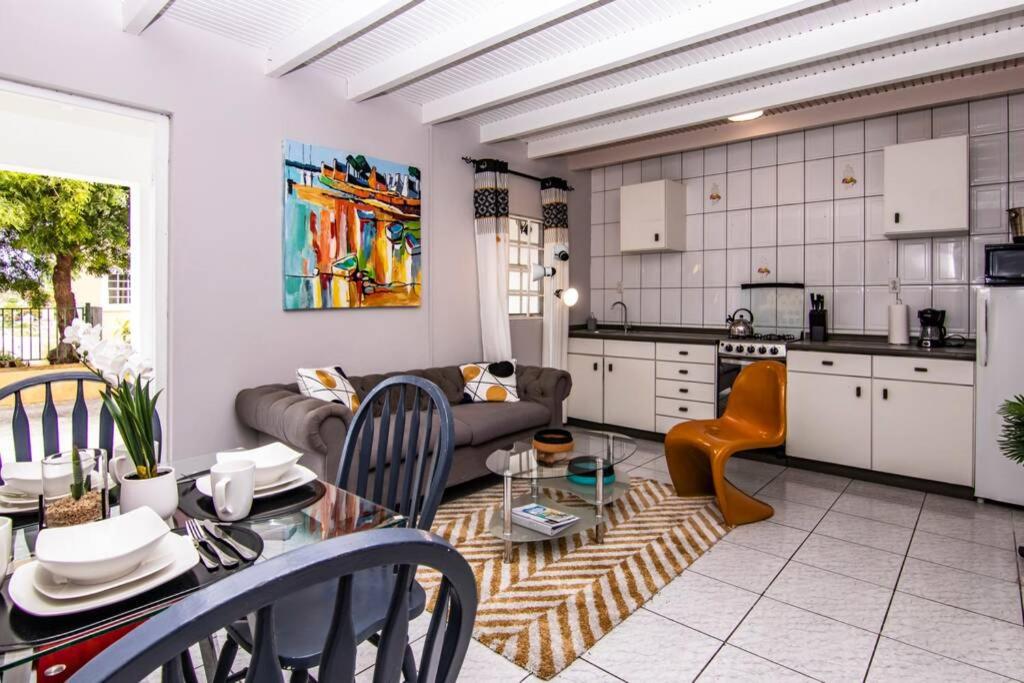 cocina y sala de estar con mesa y sofá en CityLife Apartments in Willemstad - groundfloor 2 bedroom apartment - B, en Willemstad