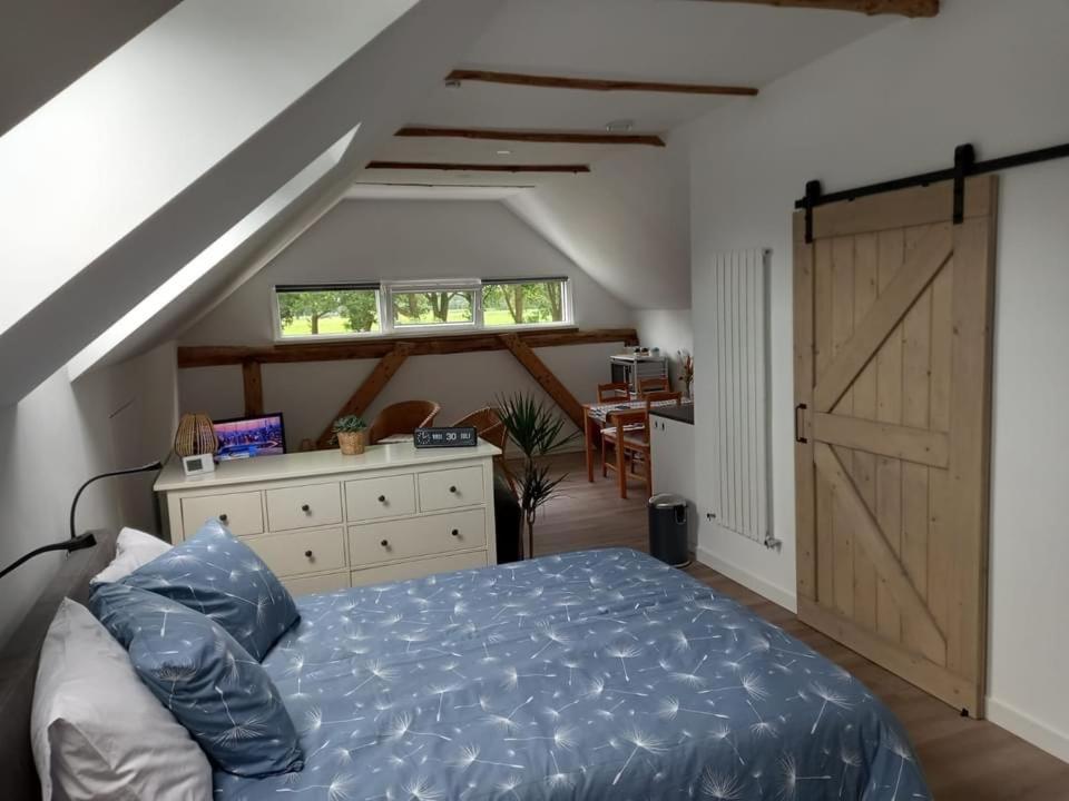 1 dormitorio con cama y puerta corredera de granero en Bed & Breakfast Beilerhorst, en Beilen