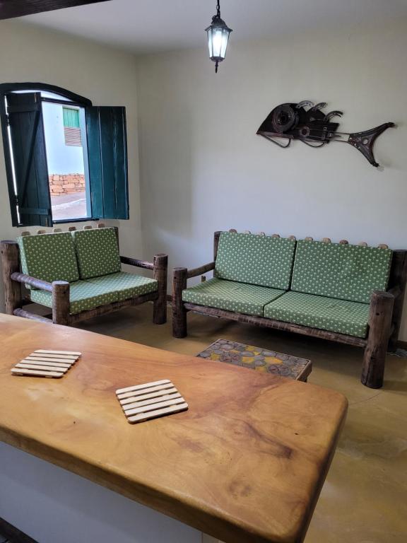 uma sala de estar com sofás verdes e uma mesa em Casa do Renato Lençóis em Lençóis