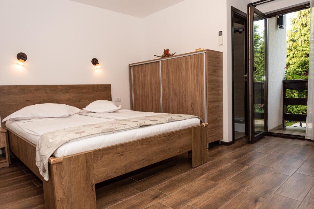 una camera da letto con un letto grande con testiera in legno di K'RAMAN a Râmnicu Vâlcea