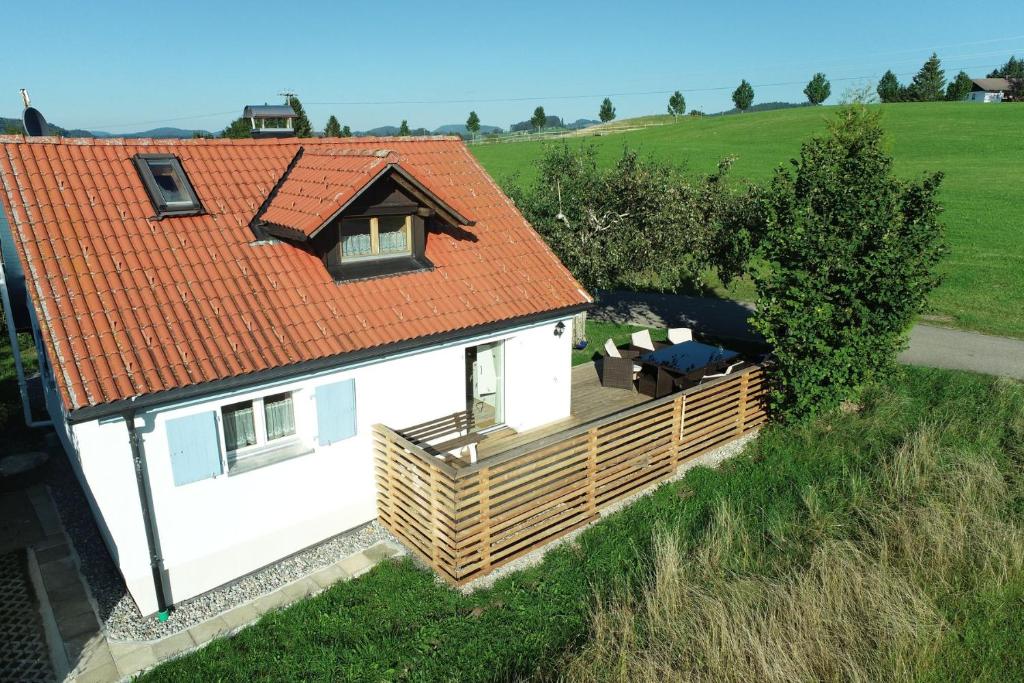 une petite maison blanche avec un toit orange dans l'établissement Knuschbrhaisle, à Oberreute
