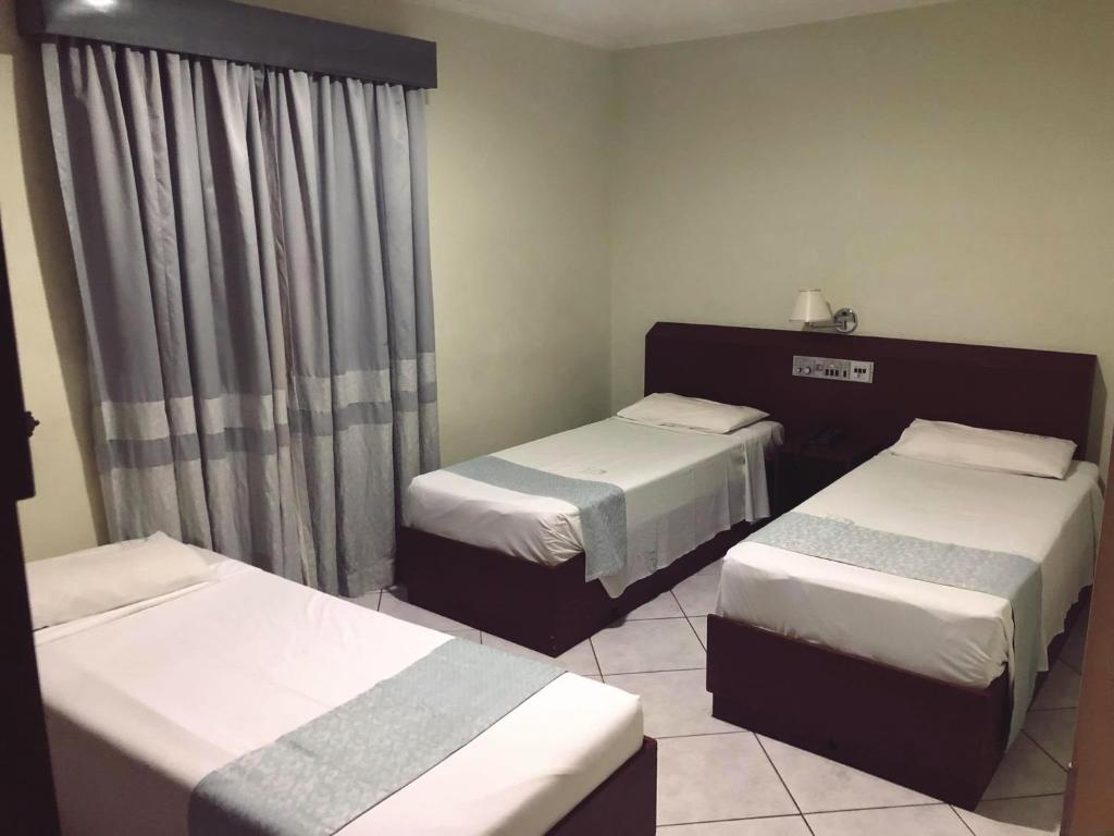 Uma cama ou camas num quarto em David Plaza Hotel