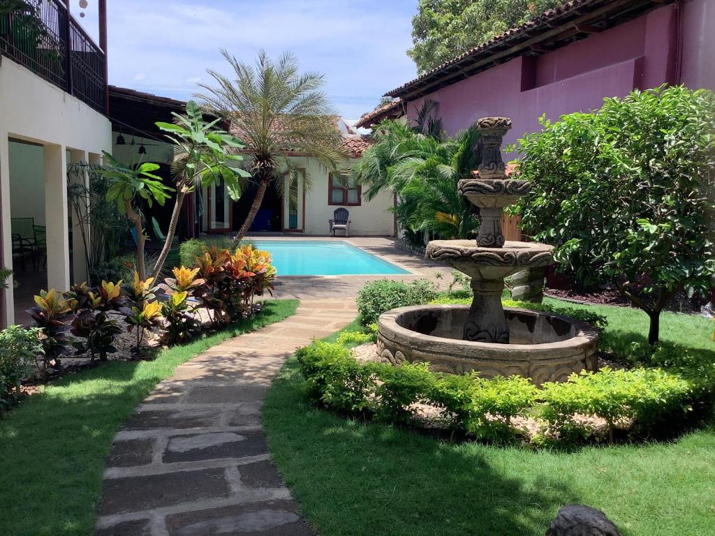 a garden with a fountain in front of a house at Casa Riverstone in León