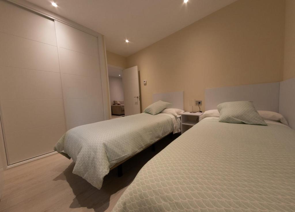 Posteľ alebo postele v izbe v ubytovaní Apartamentos Palacio de Yolanda
