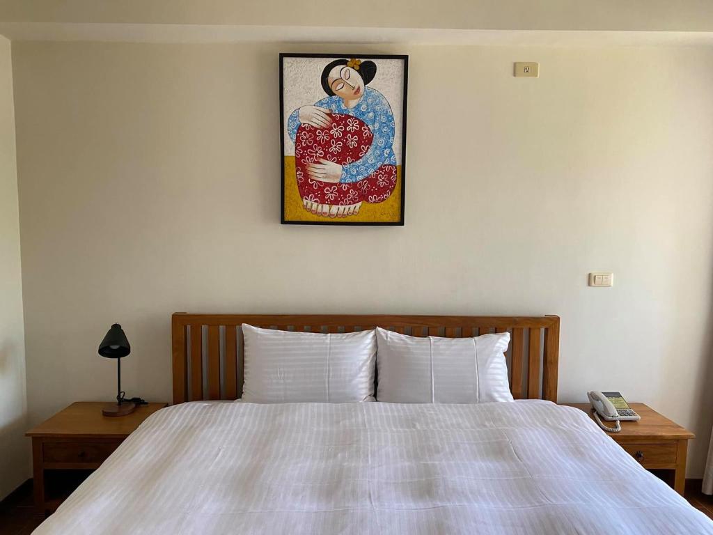 a bedroom with a bed and a picture on the wall at Mamalulu Hostel in Kenting