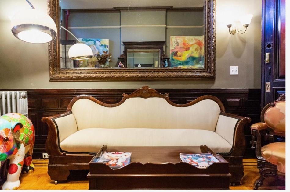 a living room with a couch and a mirror at Northern Lights Mansion in New York