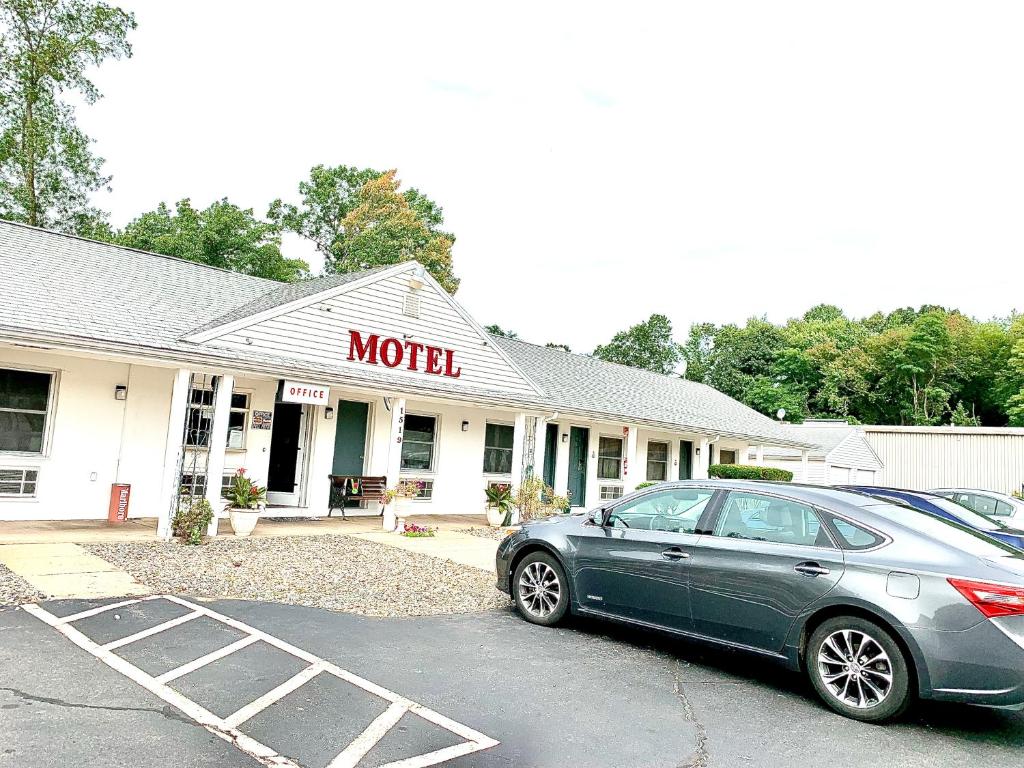 un coche aparcado en un estacionamiento frente a un motel en Nitey Nite Motel en South Windsor