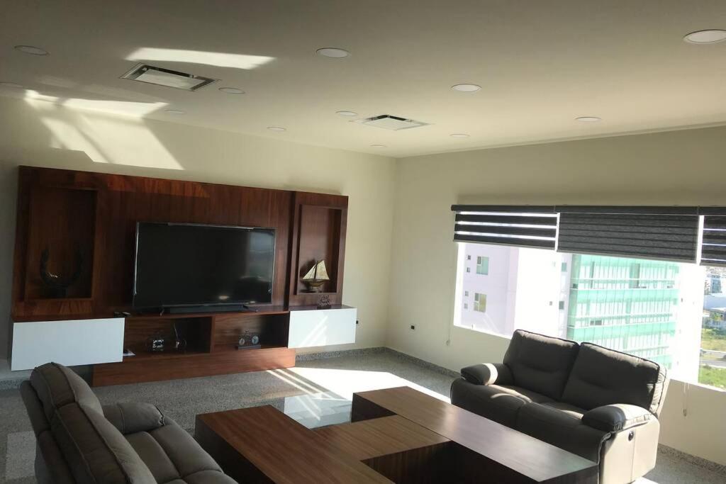 Penthouse en Irapuato في إيرابواتو: غرفة معيشة مع أريكة وطاولة وتلفزيون