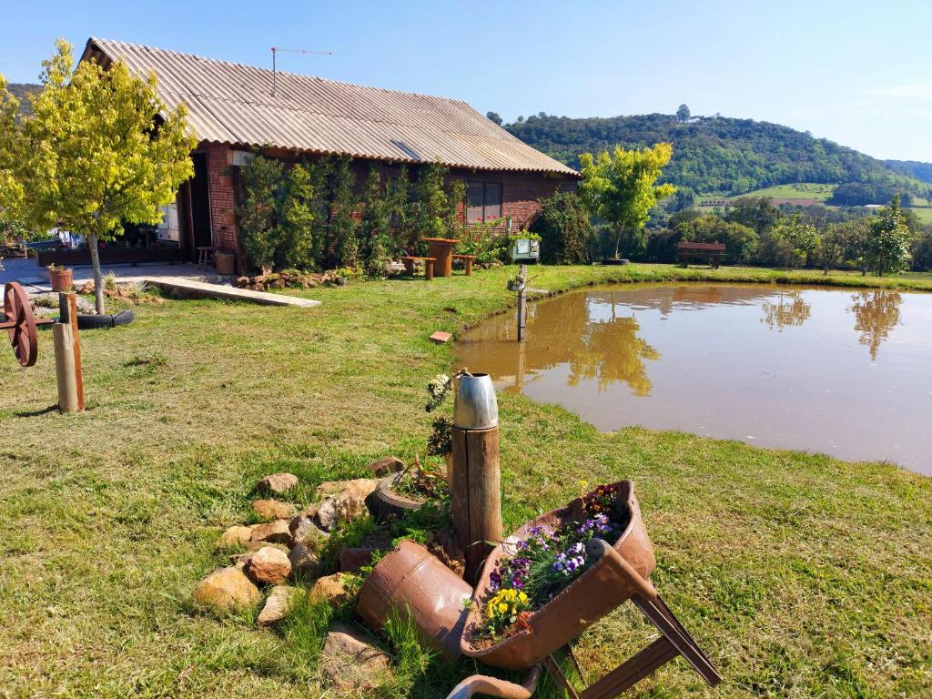 a garden in front of a house with a pond at Recanto Pôr do Sol in Nova Petrópolis