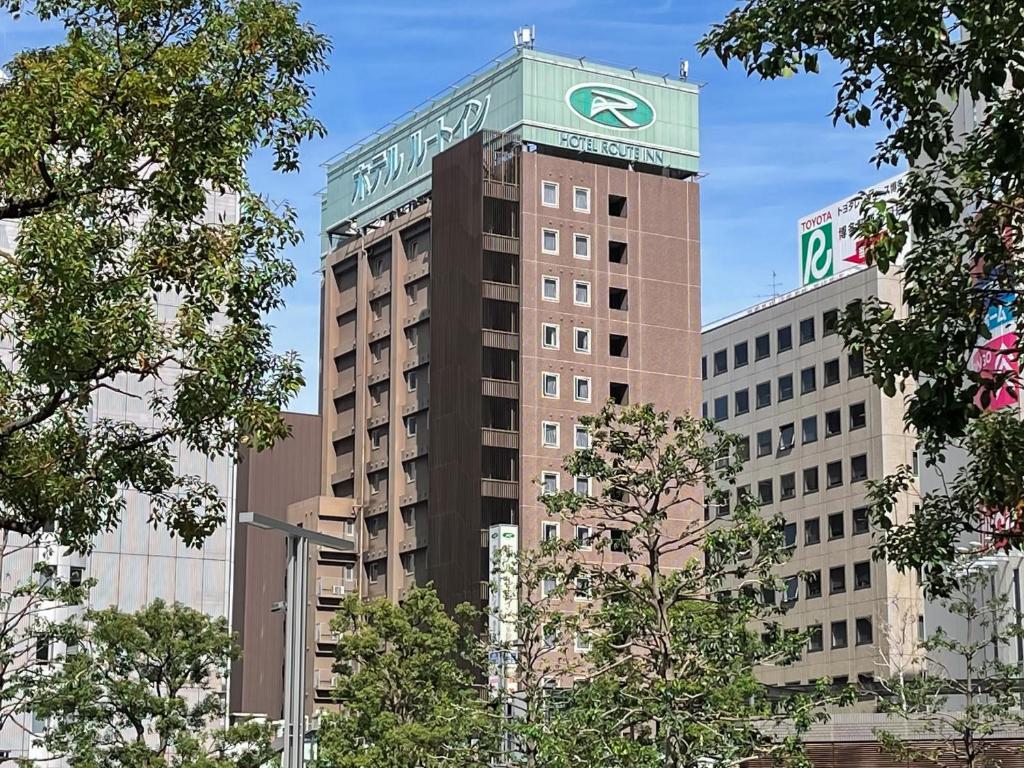 a tall building with a sign on the top of it at Hotel Route-Inn Hakata Ekimae -Hakataguchi- in Fukuoka